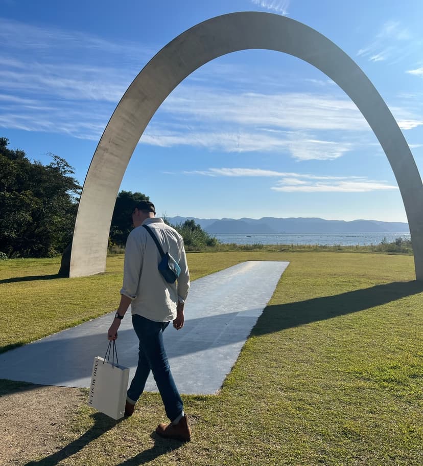 Patrick approaching a big arch on a grassy field on the coast