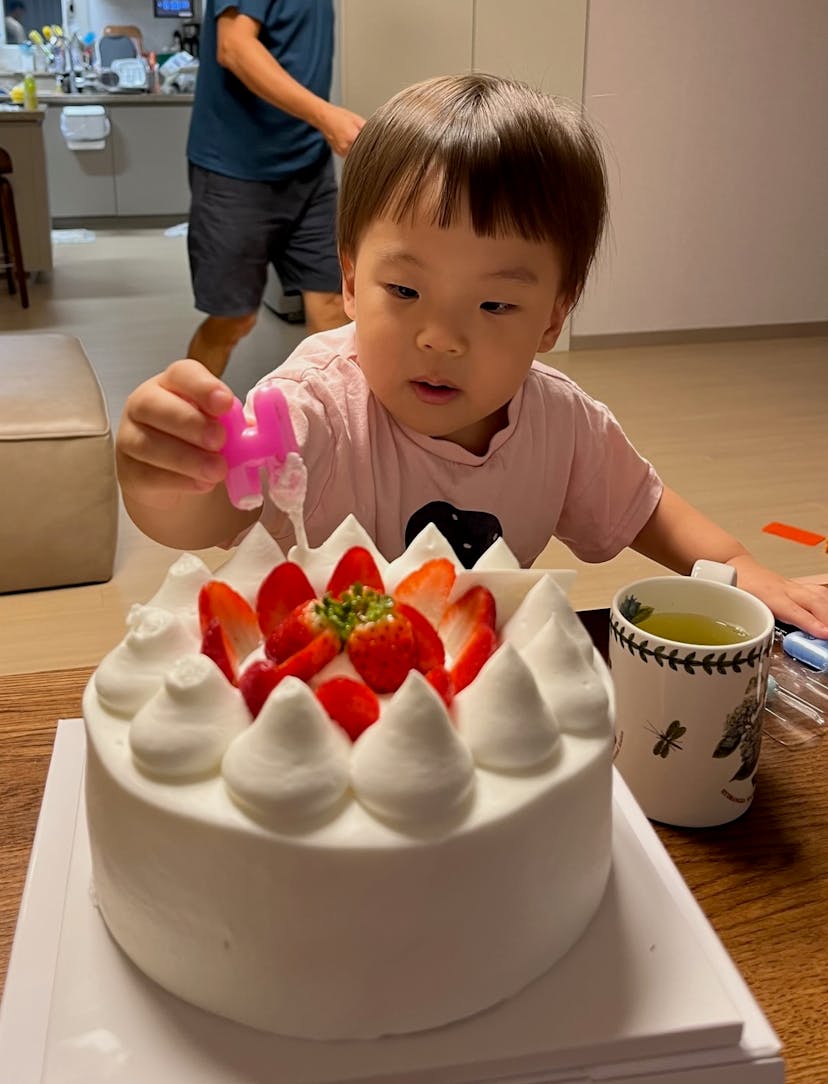 Baby Eejae putting a candle on a cake