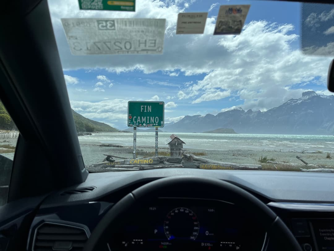 A sign that reads FIN CAMINO viewed through a windshield