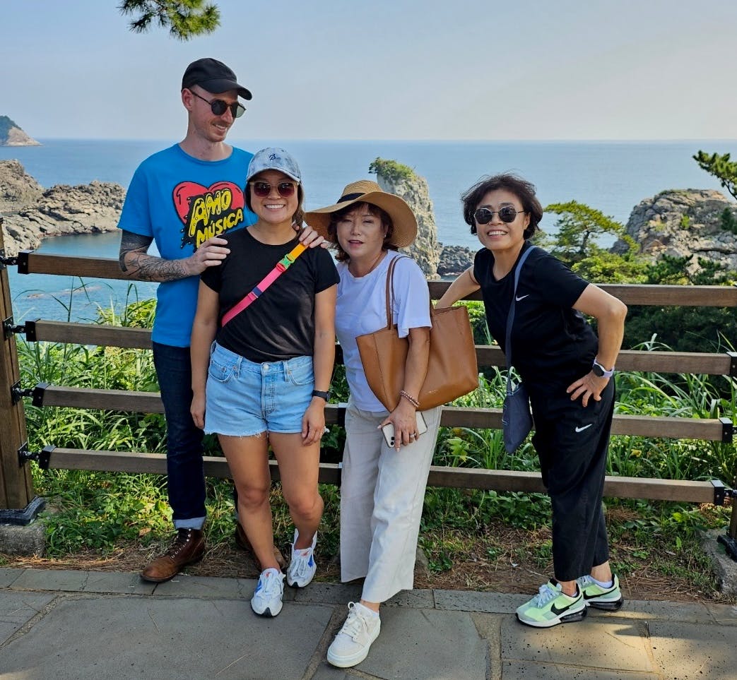 Patrick, Courtney, and family standing on a cliffside in Jeju
