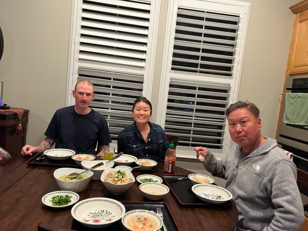 Patrick, Courtney, and Jin eating Thai food at the kitchen table