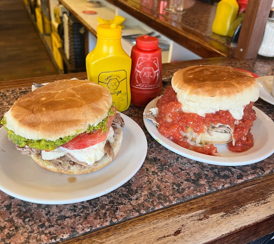 Two lomito sandwhiches on a counter