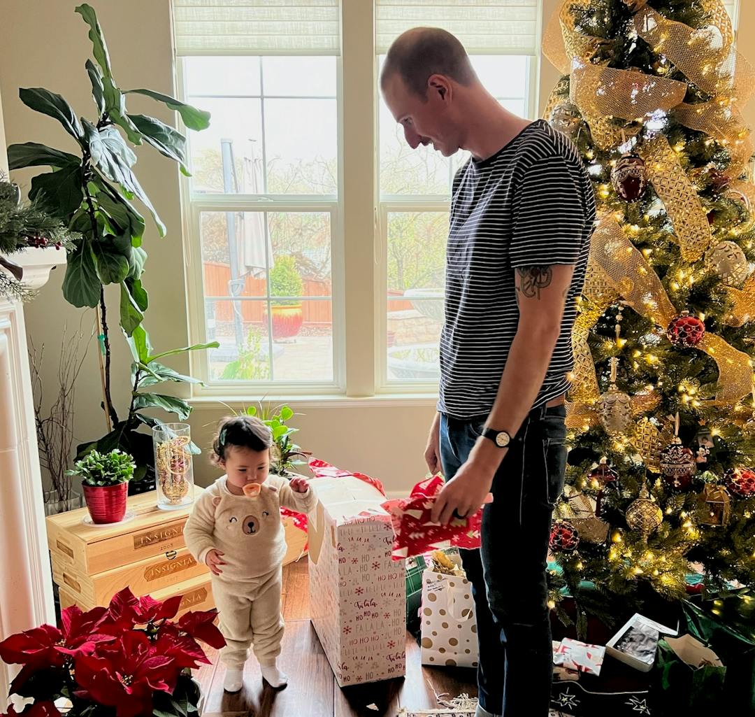 Patrick and baby Charlie opening Christmas presents