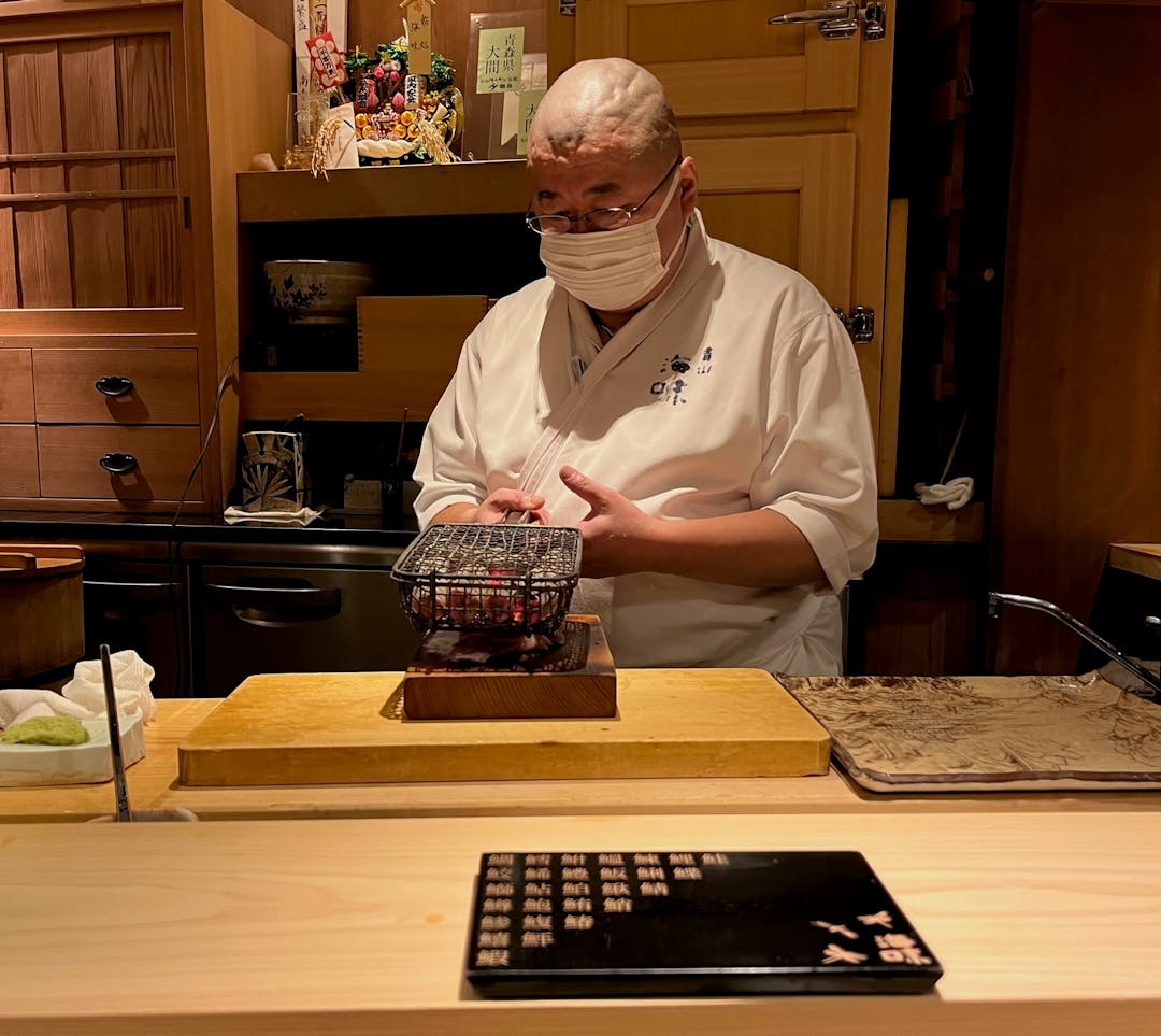 Chef heating some coals at a sushi restaurant